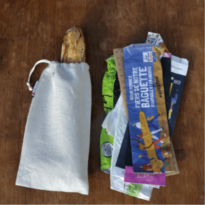 Etui mono baguette en lin beige à côté de multiples sachets baguette papiers jetables