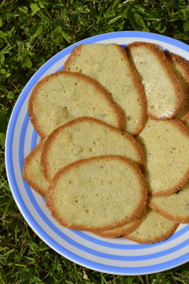 Langues de chat faites maisons posées sur une assiette bleue et blanche