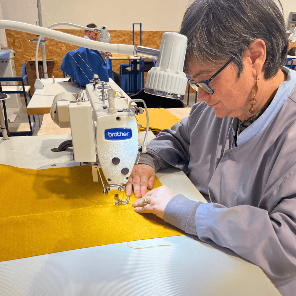 Christelle en train de coudre un sac à pain jaune