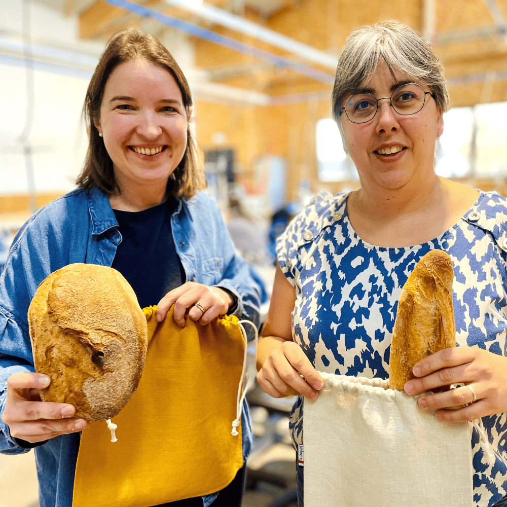 Marion et Laurence avec des sacs à pain et des pains, à l'atelier de couture