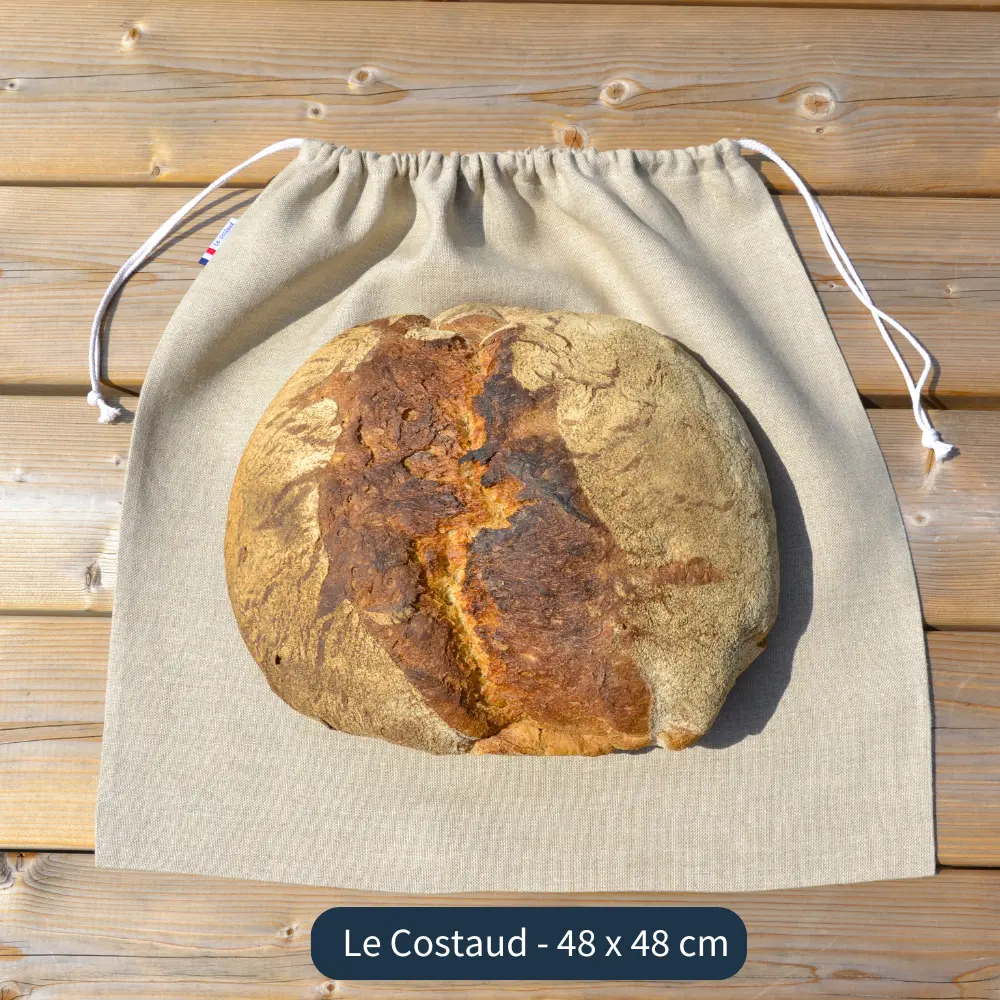 Sac à pain en lin biologique le costaud, présenté avec un gros pain au levain de 2 kg