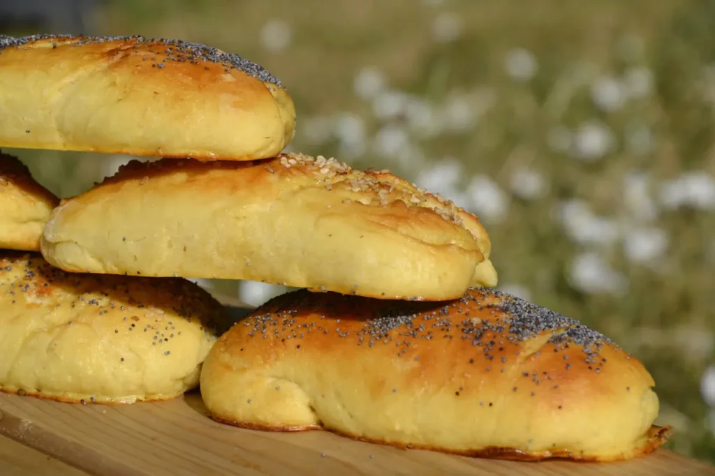Petits pains sandwichs maison bien dorés, superposés sur une planche en bois