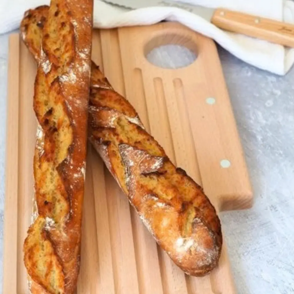 Planche à pain avec des baguettes de tradition et couteau à pain